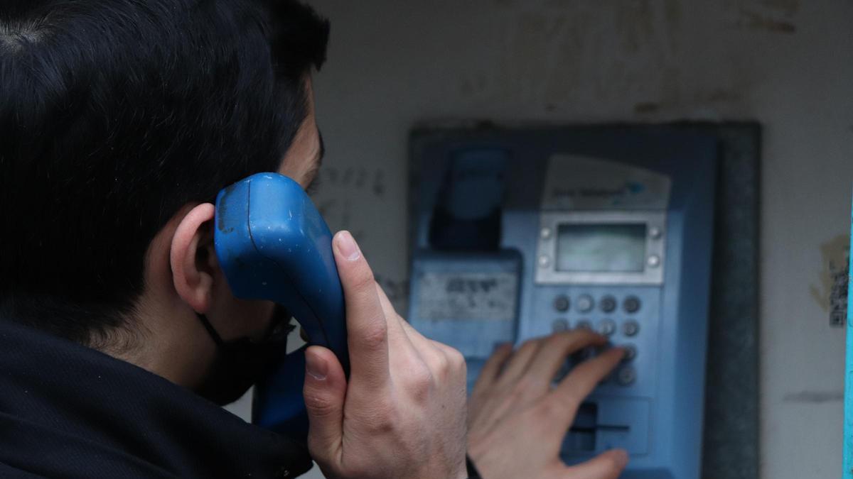 Una persona llama desde una cabina telefónica