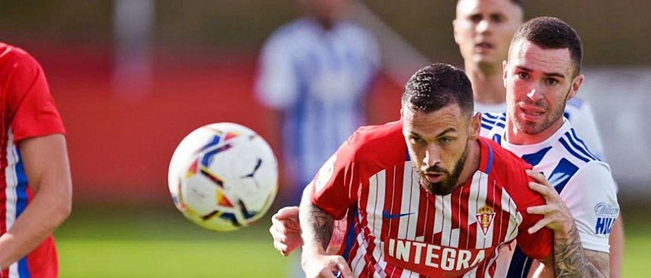 Álvaro Vázquez observa el balón ante un defensa de la Ponferradina..