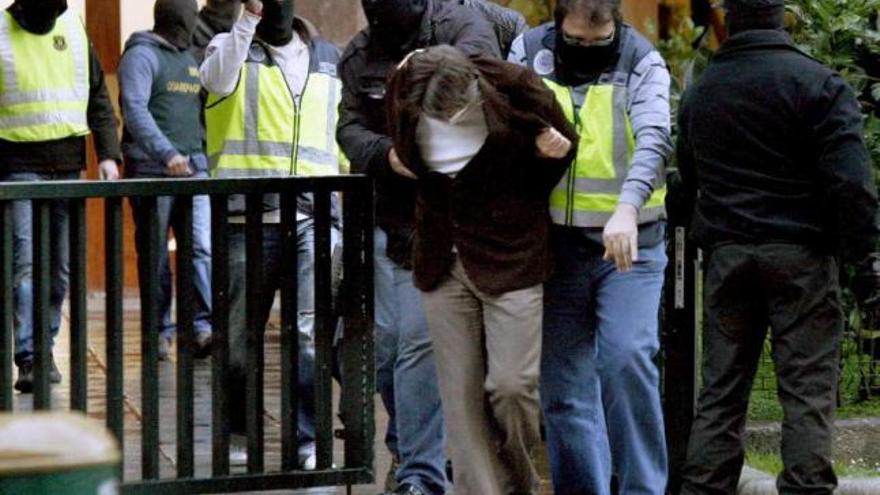 Uno de los presuntos atracadores detenidos en Bilbao, conducido por agentes de la policía. / efe