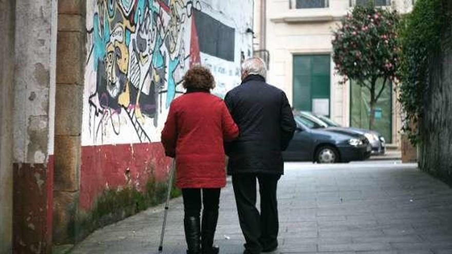 Una pareja de mayores camina por una ciudad gallega. // Bernabé / Luismy