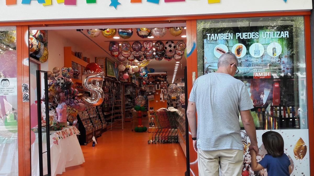 Un niño observa una tienda de regalos junto a su padre, en Madrid.