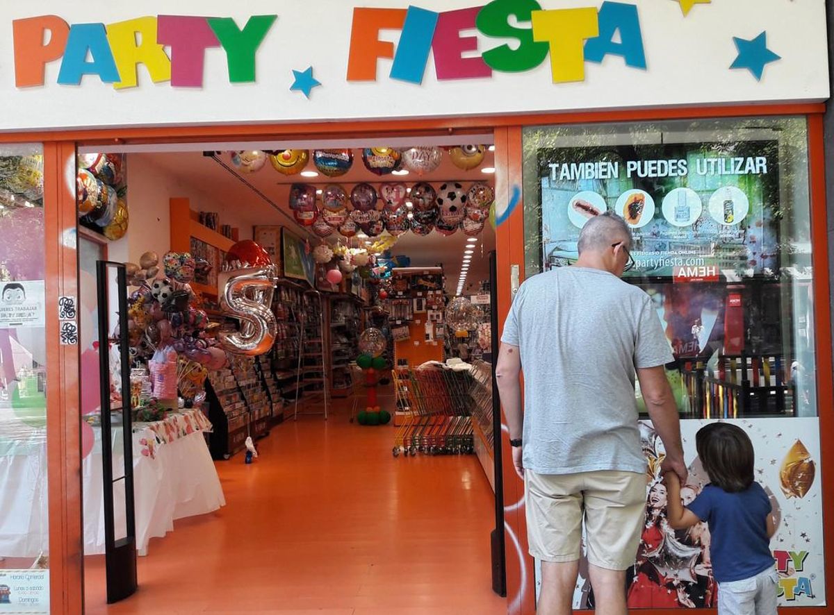 Un niño observa una tienda de regalos junto a su padre, en Madrid.