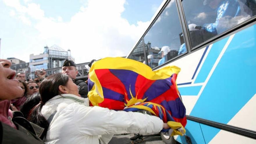 Un grupo de manifestantes pro Tíbet corren con una bandera de Tíbet junto al autobús en el que viaja la antorcha olímpica por motivos de seguridad, en París (Francia), hoy 7 de abril de 2008.