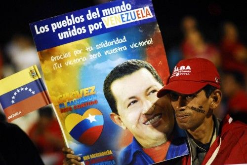 A supporter of Venezuela's President Hugo Chavez holds a poster with a photograph of Chavez in San Salvador