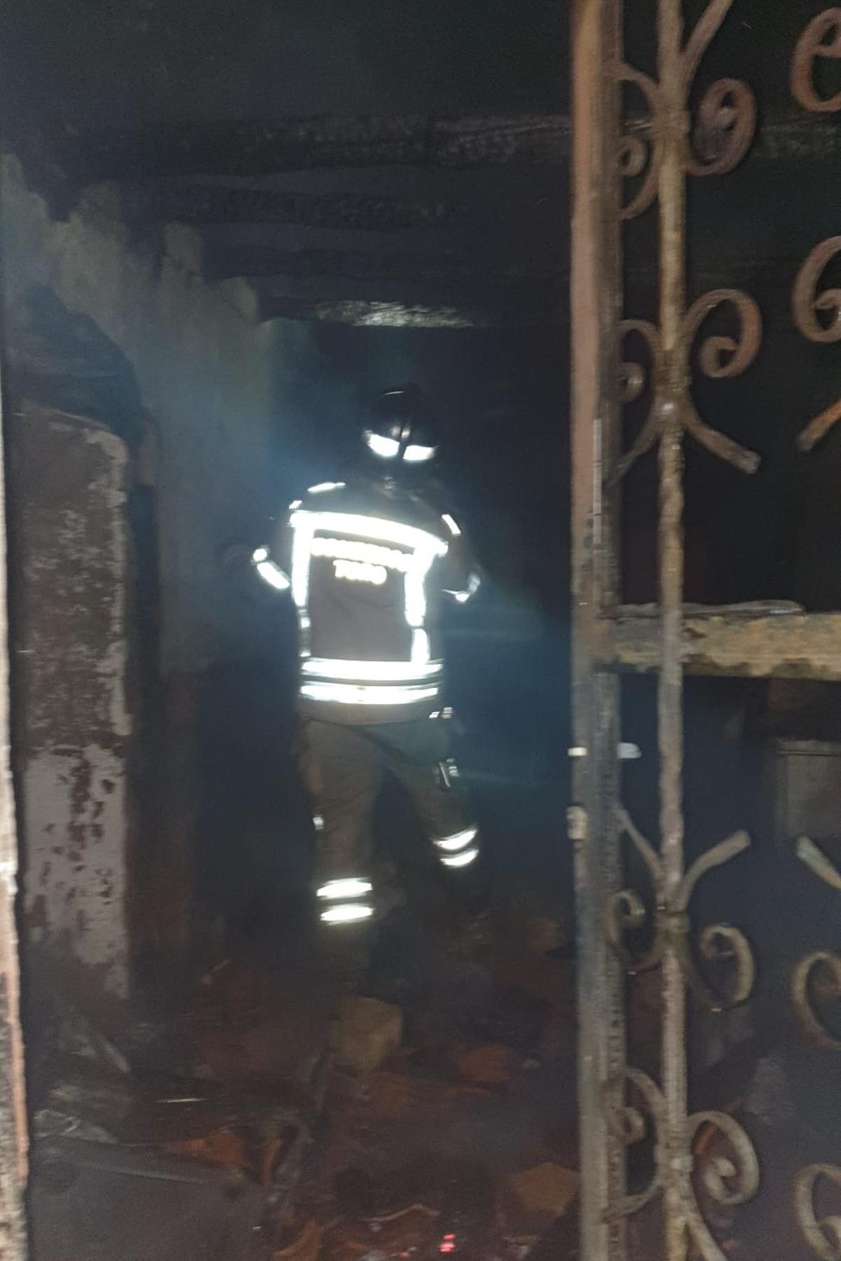 Un bombero revisa el estado de la vivienda calcinada por el fuego