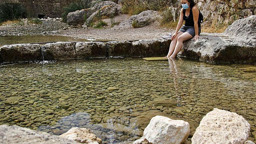 Una excursionista refrescándose en El Molinar. | JUANI RUZ