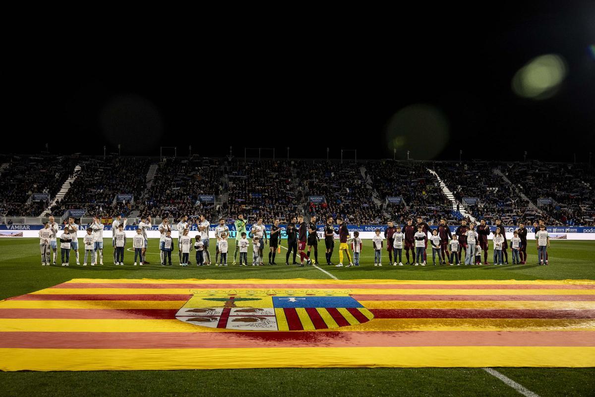 Formaciones de Real Zaragoza y SD Huesca, con la bandera de Aragón sobre el césped antes del derbi de la primera vuelta en el Ibercaja Estadio.