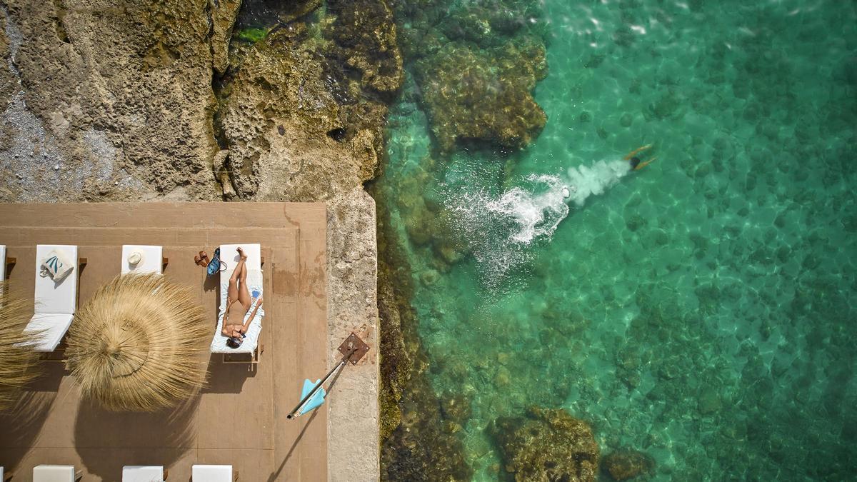 Disfruta de un día de verano descansando en su zona de hamacas y bañándote en el mar.