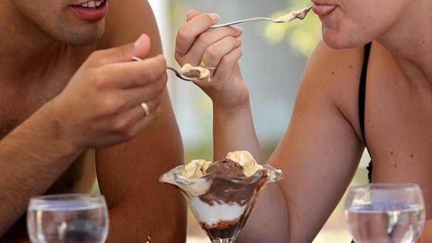 Una pareja saborea un helado en una terraza de la Playa del Postiguet