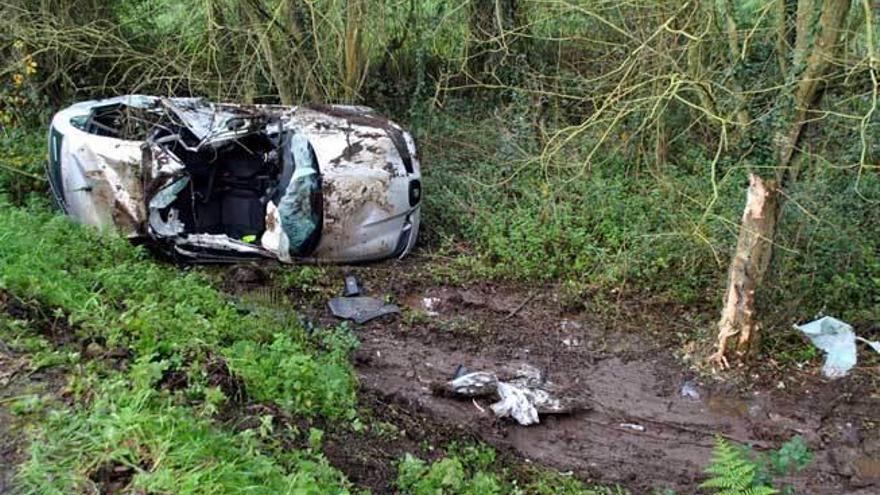 El turismo, volcado tras el accidente.