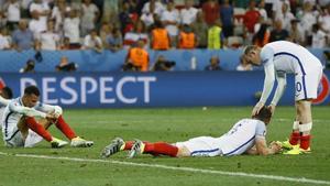Rooney intenta consolar a sus compañeros tras la debacle inglesa ante Islandia.