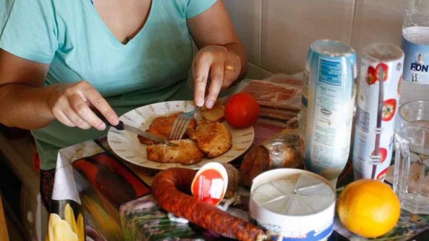 Una mujer, ante una bandeja y una mesa repletas de comida .