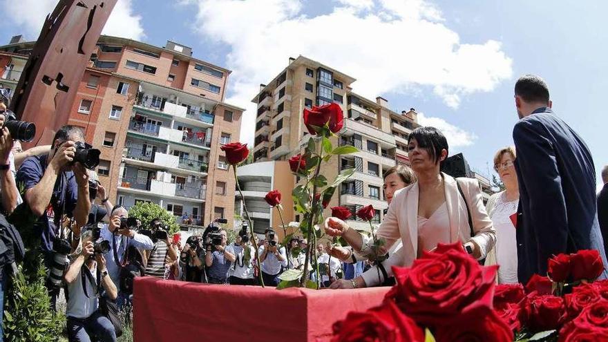 La parlamentaria de Bildu Maddalen Iriarte pone una rosa para recordar al concejal del PP. // Efe