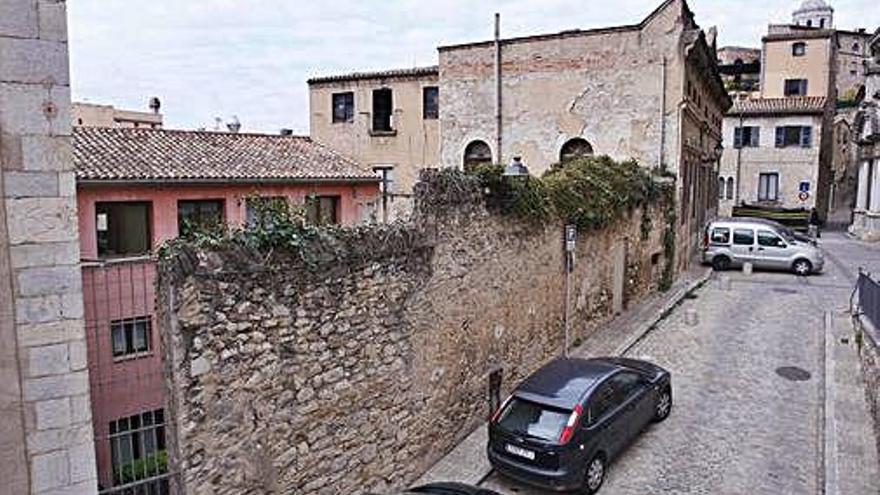 Exterior del pati, protegit per un mur i una porta metàl·lica.