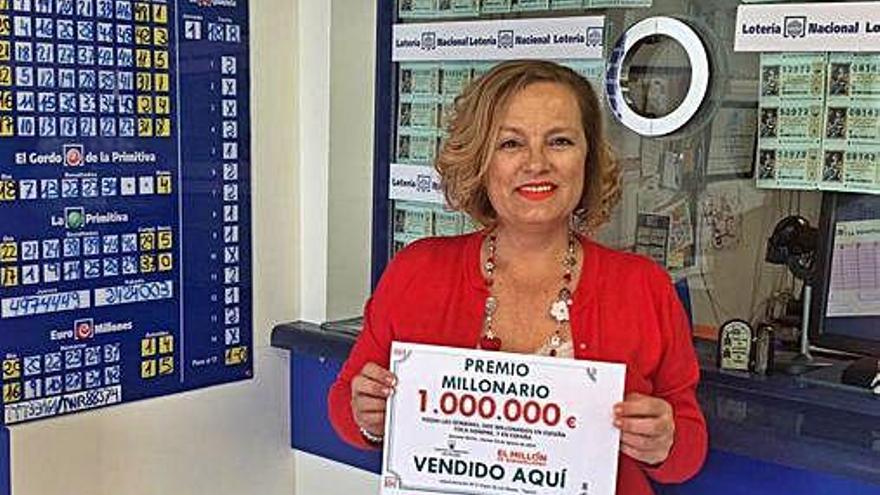 Inés Francisco, ayer, en su administración de Teguise con el cartel del premio del millón de euros de Euromillones.