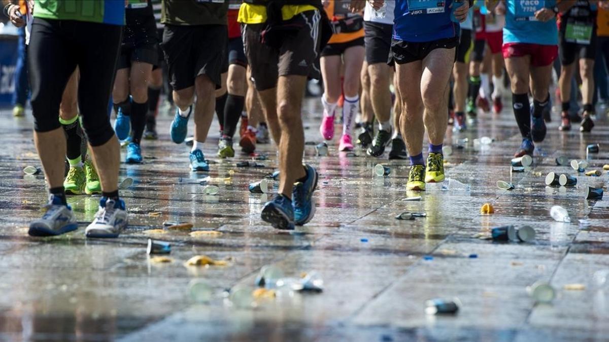 Un grupo de corredores pasa por uno de los controles de avituallamiento del maratón de Barcelona