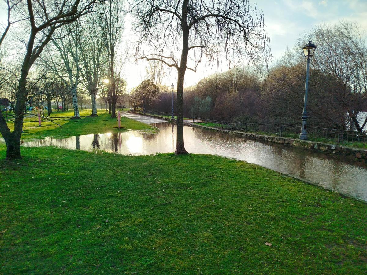 Botas Katiuskas y mucho 'valor' para pasear por el parque del Cachón de Plasencia, tras las lluvias.