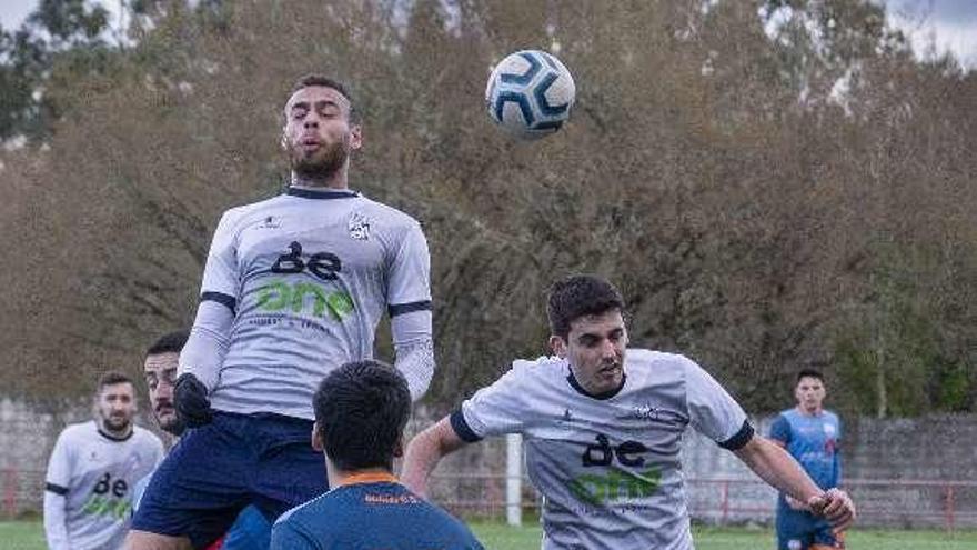 La pelota, entre dos visitantes, ayer, en Maside. // Carlos Peteiro