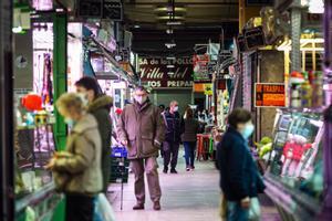 Los clientes observan los puestos del Mercado de Maravillas de Madrid.