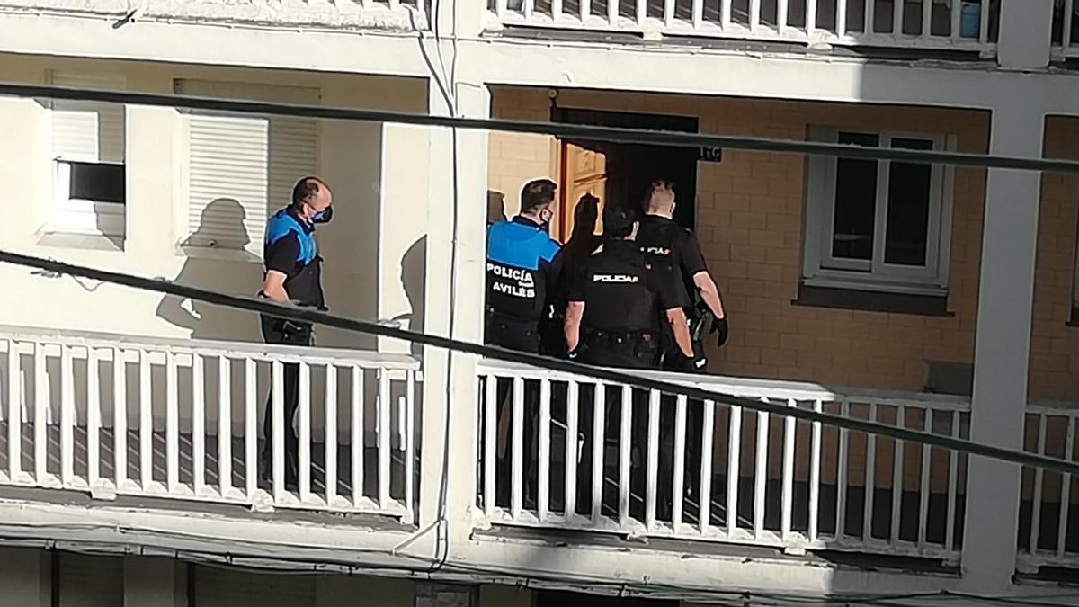Agentes de las policías Nacional y Local acceden a la vivienda donde se halló el cuerpo.