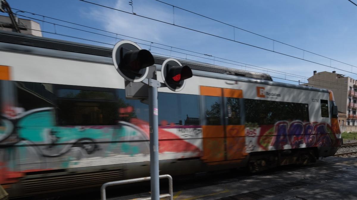 Un tren en el pas a nivell de Figueres. | EMPORDA.INFO