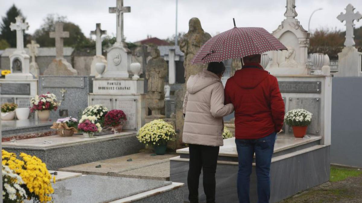 Una pareja ante el sepulcro de sus deudos. |   // BERNABÉ/LUCÍA ABELEDO