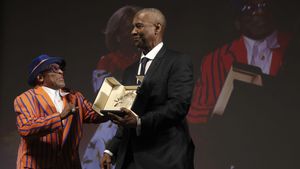 US actor Denzel Washington, right, receive from director Spike Lee an Honorary Palme dOr (Golden Palm) ahead of the screening of the film Highest 2 Lowest at the 78th edition of the Cannes Film Festival in Cannes, southern France, Monday, May 19, 2025. (Valery Hache, Pool via AP). POOL PHOTO
