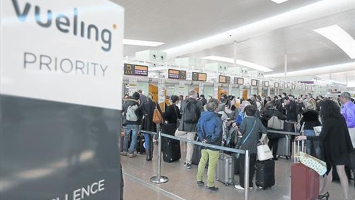 Colas de pasajeros en los mostradores de facturación de Vueling en El Prat .