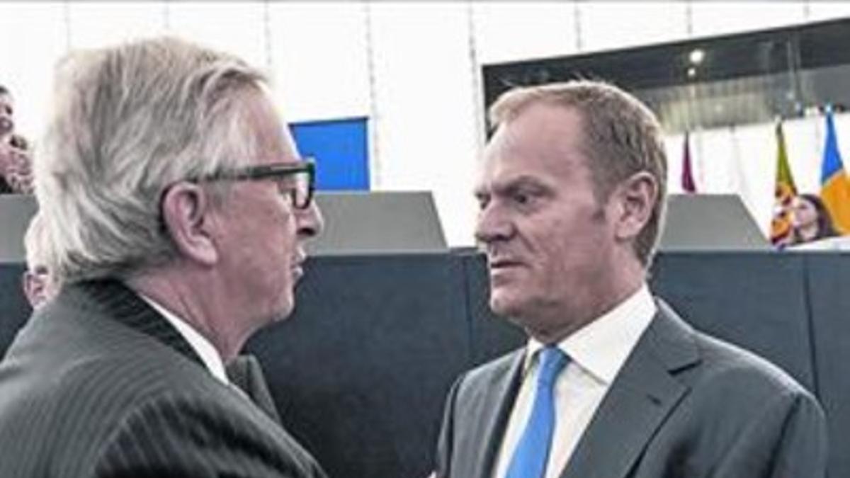 Juncker (izq.) saluda a Donald Tusk, presidente del Consejo Europeo.