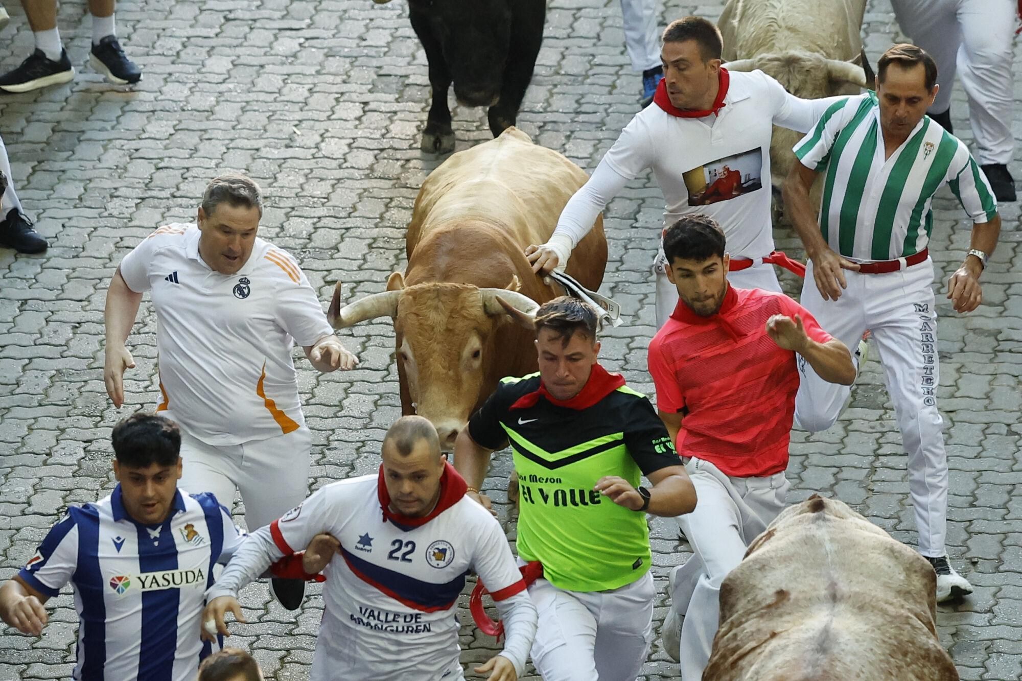 PAMPLONA, 09/07/2025.- Los mozos son perseguidos por los toros de la ganadería Álvaro Núñez durante el tercer encierro de los Sanfermines 2025 este miércoles en Pamplona. EFE/Villar López