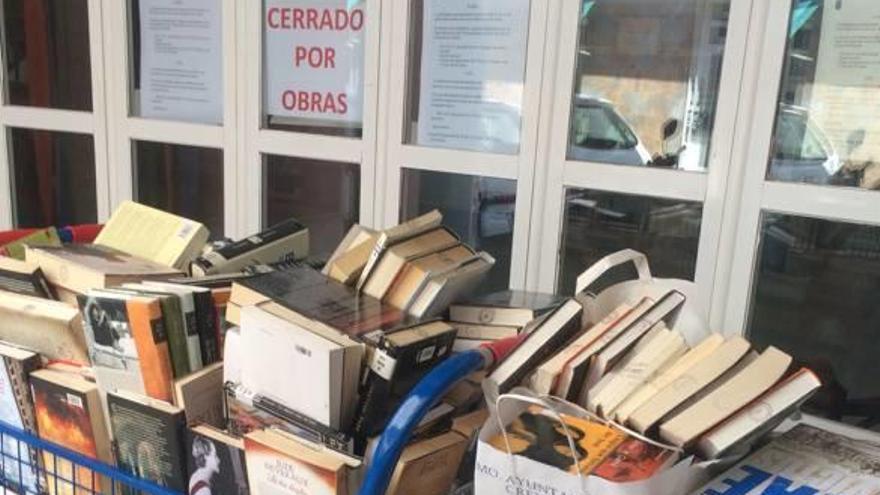 Libros amontonados a las puertas de la Biblioteca Enric Valor de Crevillent, cerrada por las obras.