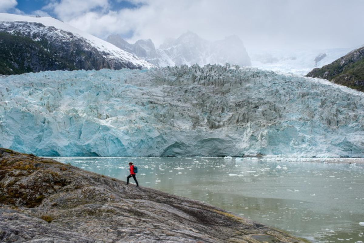 Un viajero y, al fondo, un glaciar.