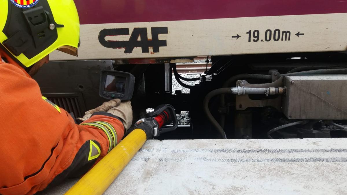 Uno de los bomberos comprueba el eje de transmisión que había resultado afectado por el fuego