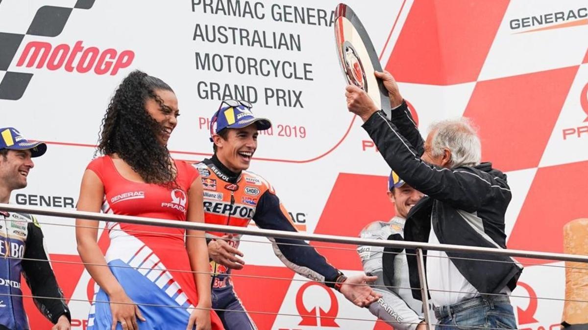 El mítico piloto italiano Giacomo Agostini le entrega el premio de vencedor, en Phillip Island, a Marc Márquez.