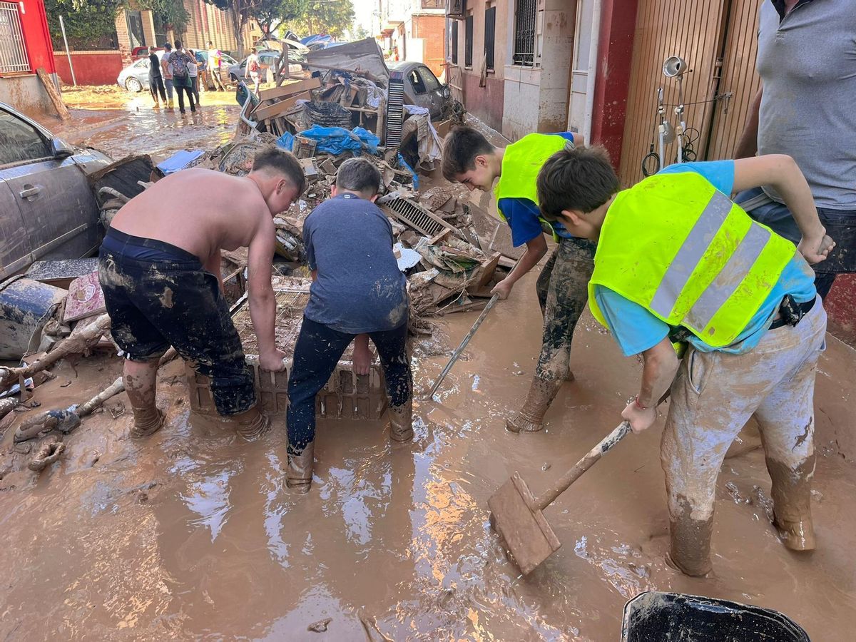 Álvaro, Eric, Hugo y Pablo retiran fango de las calles de Massanassa.
