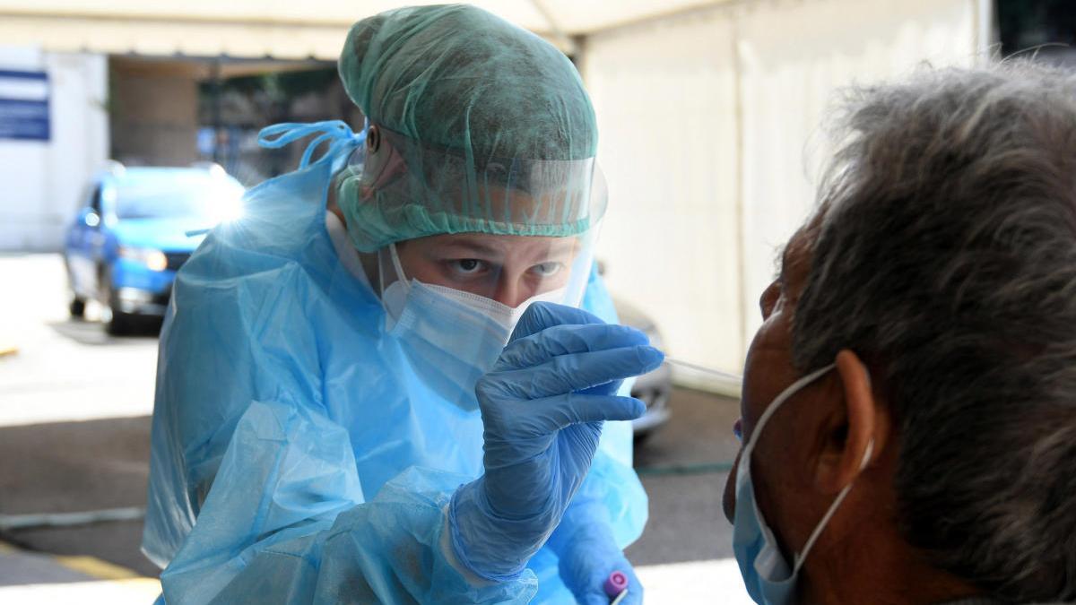 Una profesional sanitaria realizando una PCR a un paciente en el Hospital Provincial.