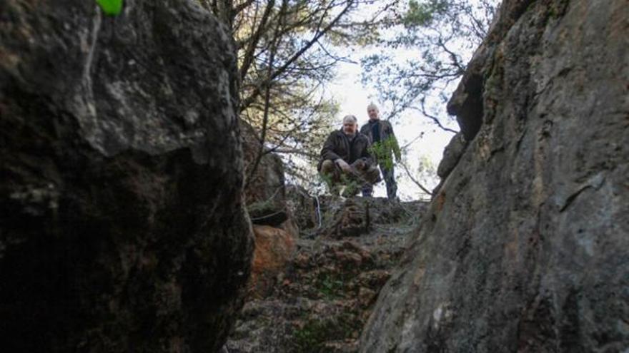 El arqueólogo, en cuclillas, observa una de las zanjas de prospección de las antiguas minas.