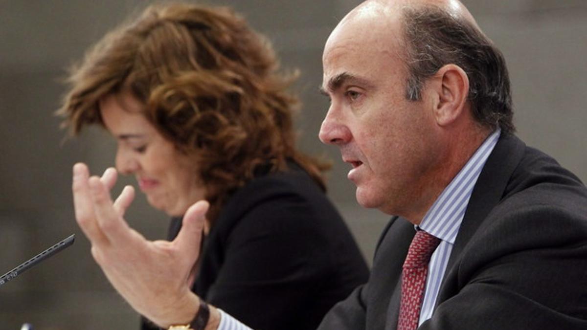 Luis de Guindos, con Soraya Saenz de Santamaría, tras el Consejo de Ministros.