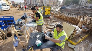 Operarios de telecomunicaciones reparan la red de fibra óptica en Paiporta (Valencia) tras los daños sufridos por la dana.
