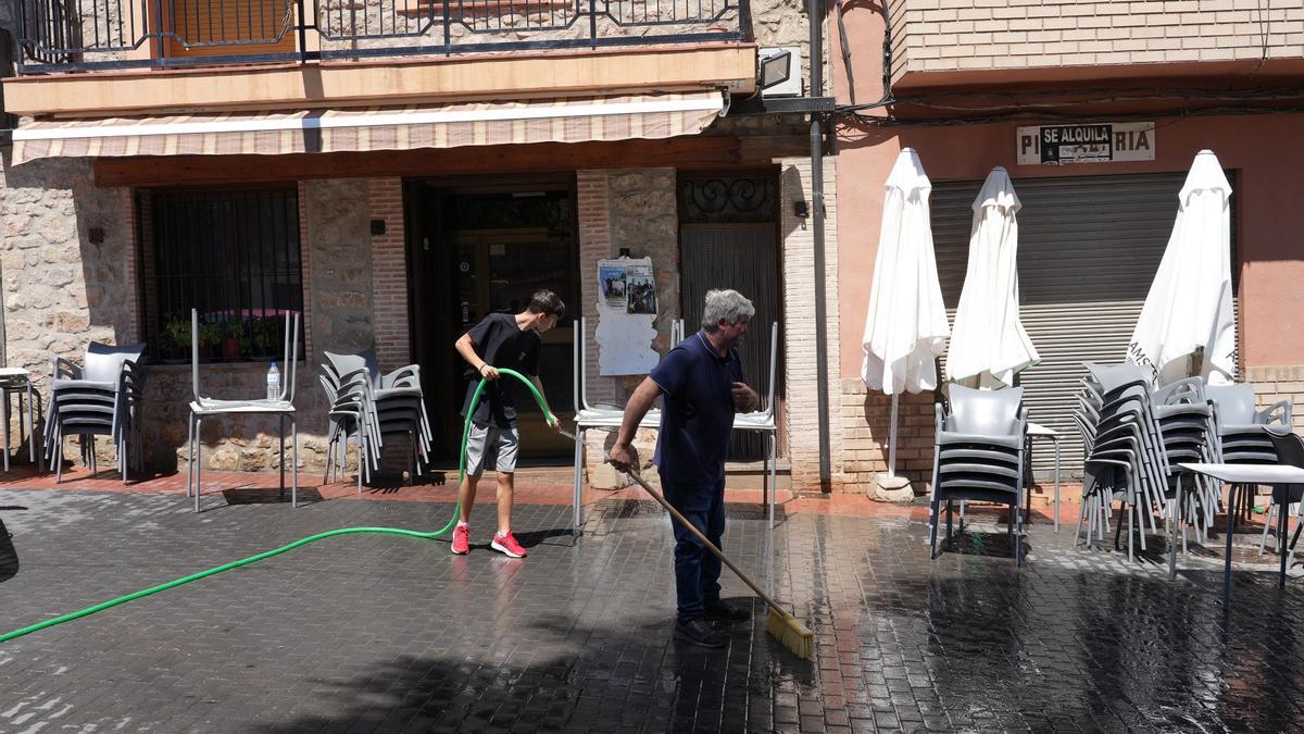 Empleados de un bar de Bejís limpian la terraza para poder retomar la actividad.