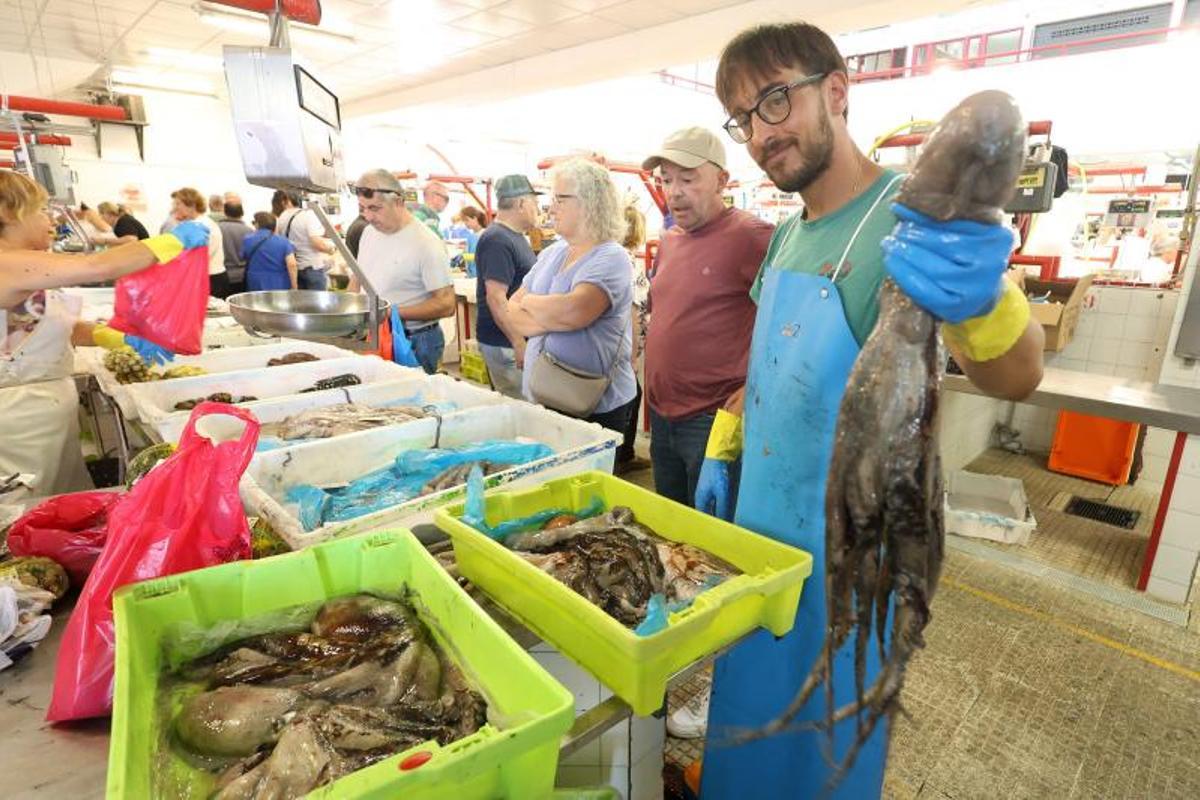 Un vendedor sostiene un pulpo en la plaza de Cambados.