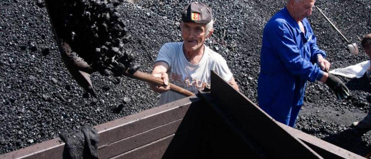 Jubilados de Hunosa recogen su vale de carbón en el pozo Candín.