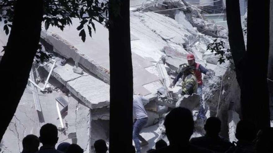 Equipos de rescate y voluntarios en un edificio derruido.