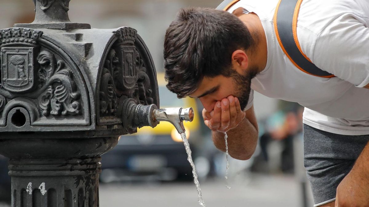 El hombre bebiendo agua en una fuente.