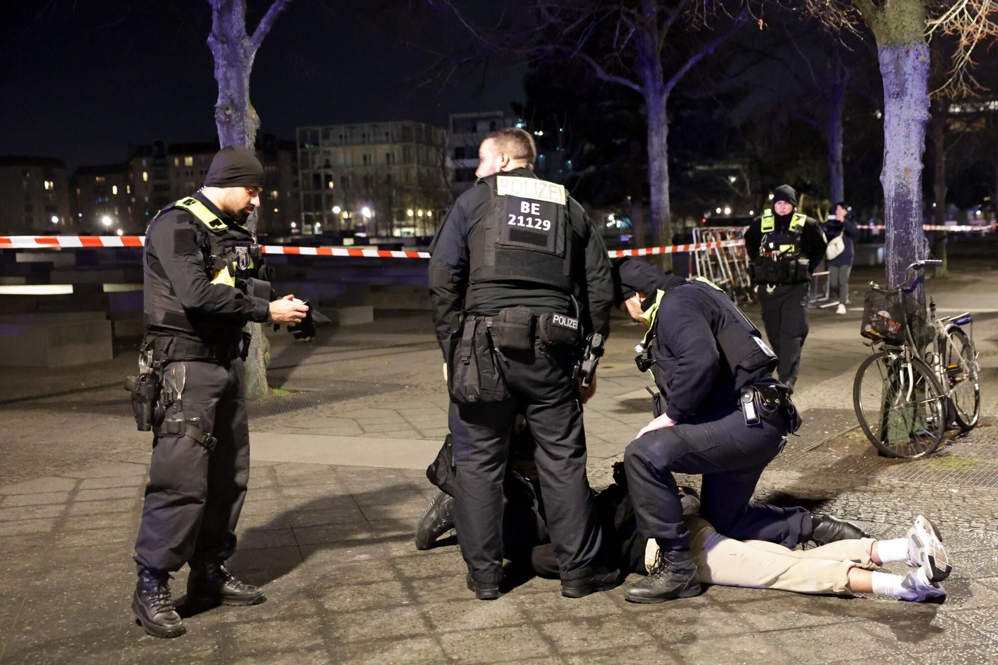 Berlin (Germany), 21/02/2025.- Police officers arrest a man near the Holocaust Memorial in Berlin, Germany, 21 February 2025, after another man was seriously injured with a sharp object. The injured man was taken to hospital and an investigation is ongoing at the crime scene. (Alemania) EFE/EPA/CHRISTOPHER NEUNDORF