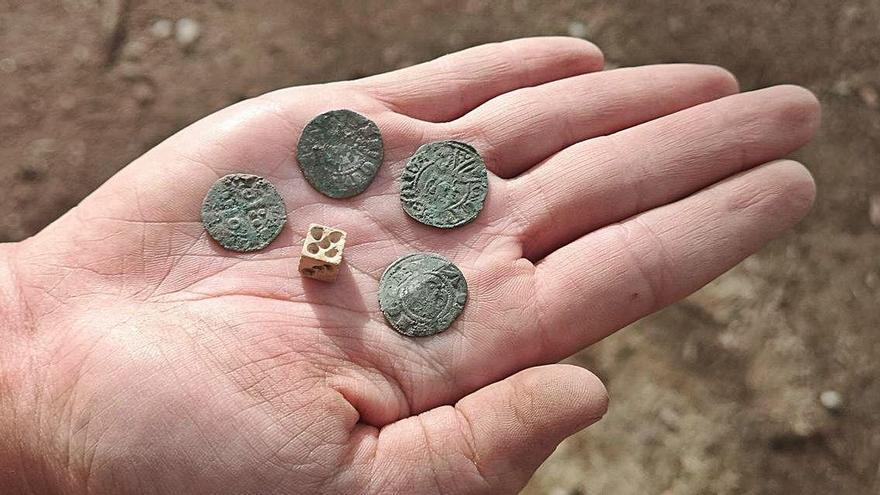 Algunes de les monedes i un dau d&#039;os aparegut a les excavacions