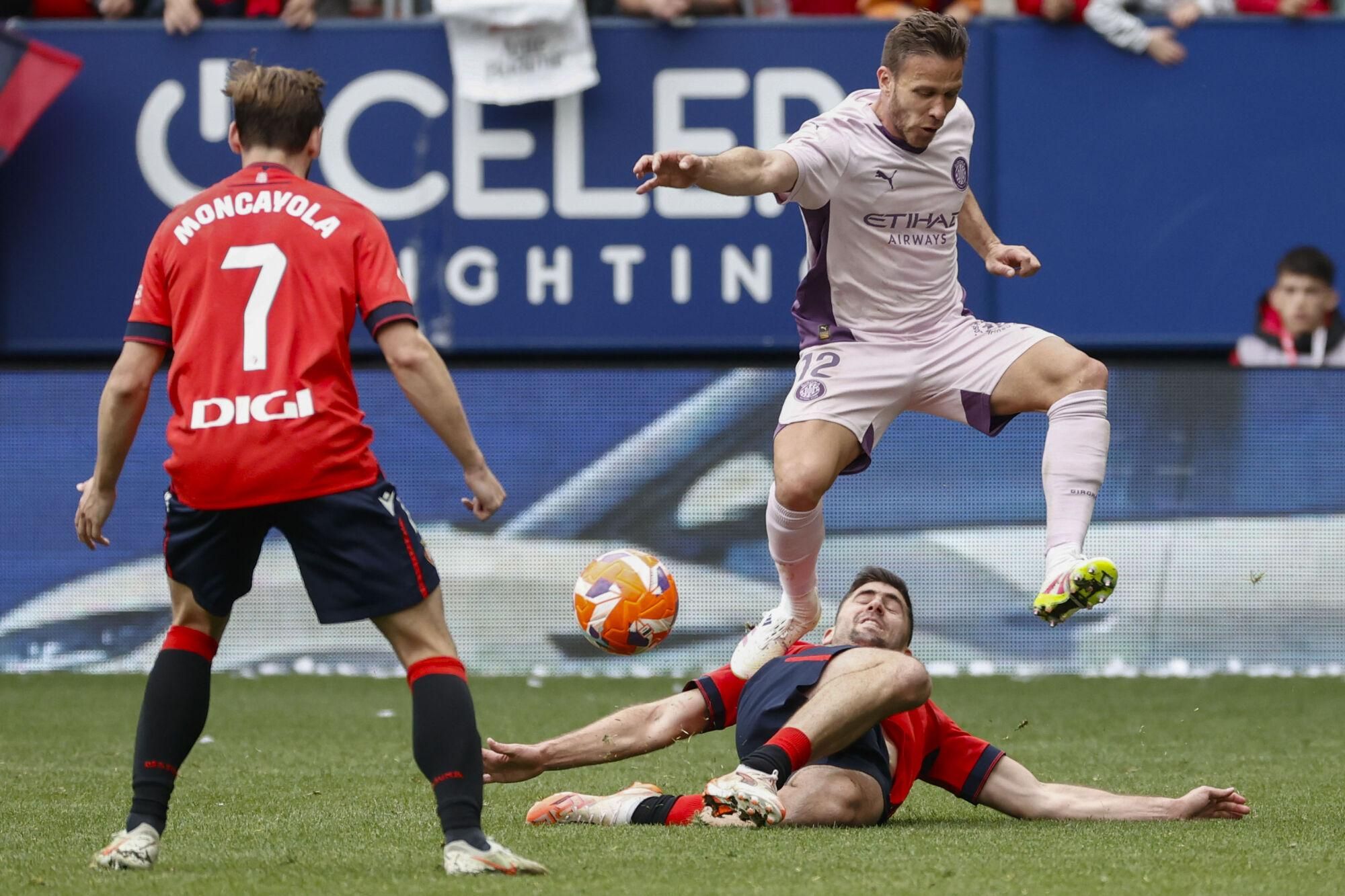 PAMPLONA, 13/04/2025.- El centrocampista del Osasuna Jon Moncayola (debajo) disputa un balón con el centrocampista del Girona Arthur Melo durante el partido que disputan, este domingo, en el estadio de El Sadar, correspondiente a la jornada 31 de Laliga. EFE/ Jesús Diges