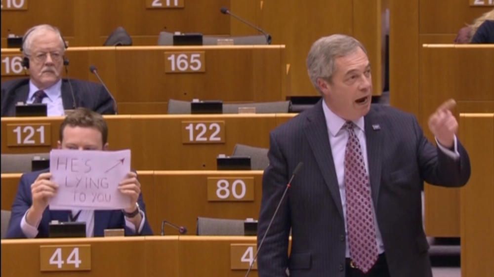 Un miembro del Partido Laborista sabotea el discurso de Nigel Farage, del UKIP, en el Parlamento Europeo, con un cartel que dice "Te está mintiendo".