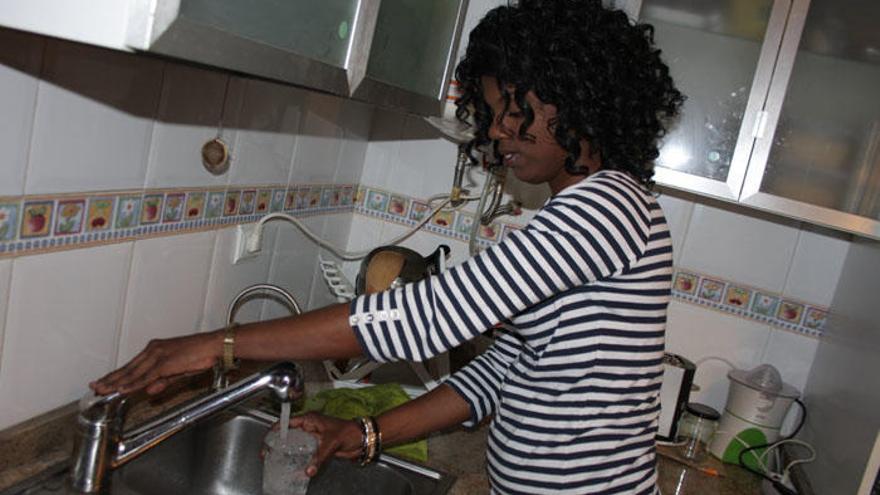 Una vecina de Fuente de Piedra llena un vaso de agua en su vivienda.