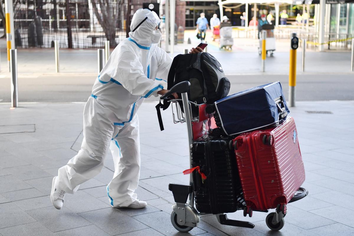 Un viajero viste un traje protector a su llegada al aeropuerto de Sídney, en Australia obligan a usar mascarillas al aire libre Un viajero viste un traje protector a su llegada al aeropuerto de Sídney, en Australia obligan a usar mascarillas al aire libre